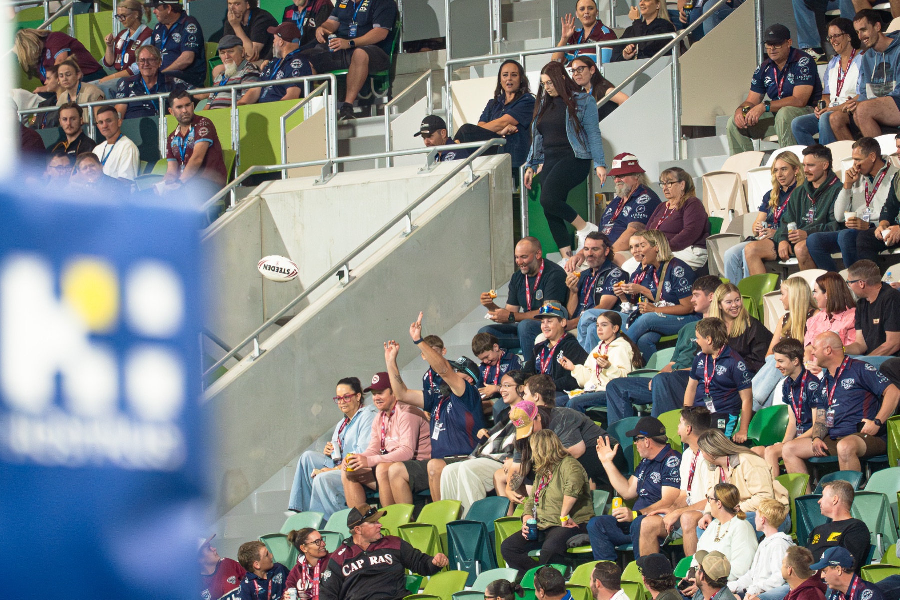 Half Way Club members cheering in the stands above the halfway line